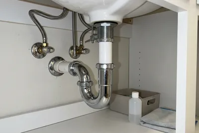 Freshly repaired pipe under bathroom sink